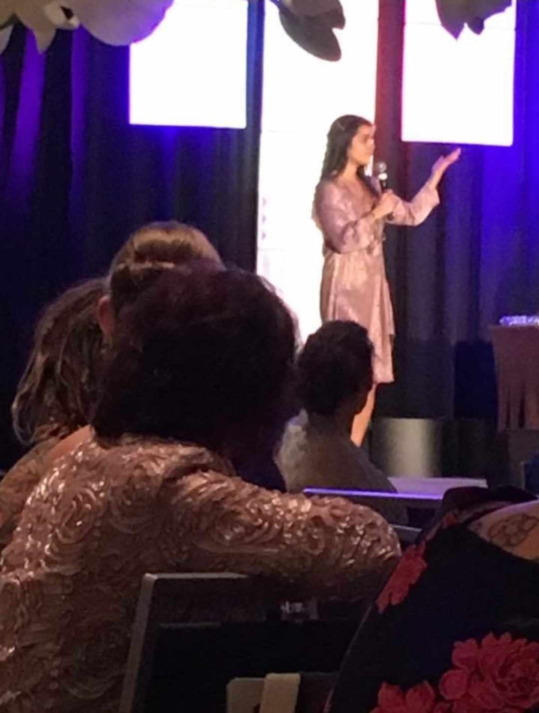 Briana speaking on stage at the Edge Gala