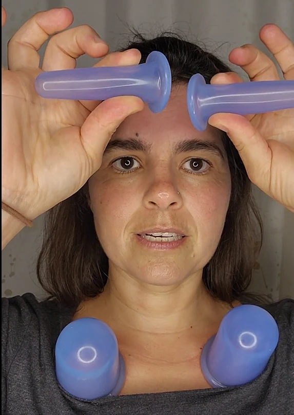 Briana J. Sabaj holding two facial cupping cups near her forehead