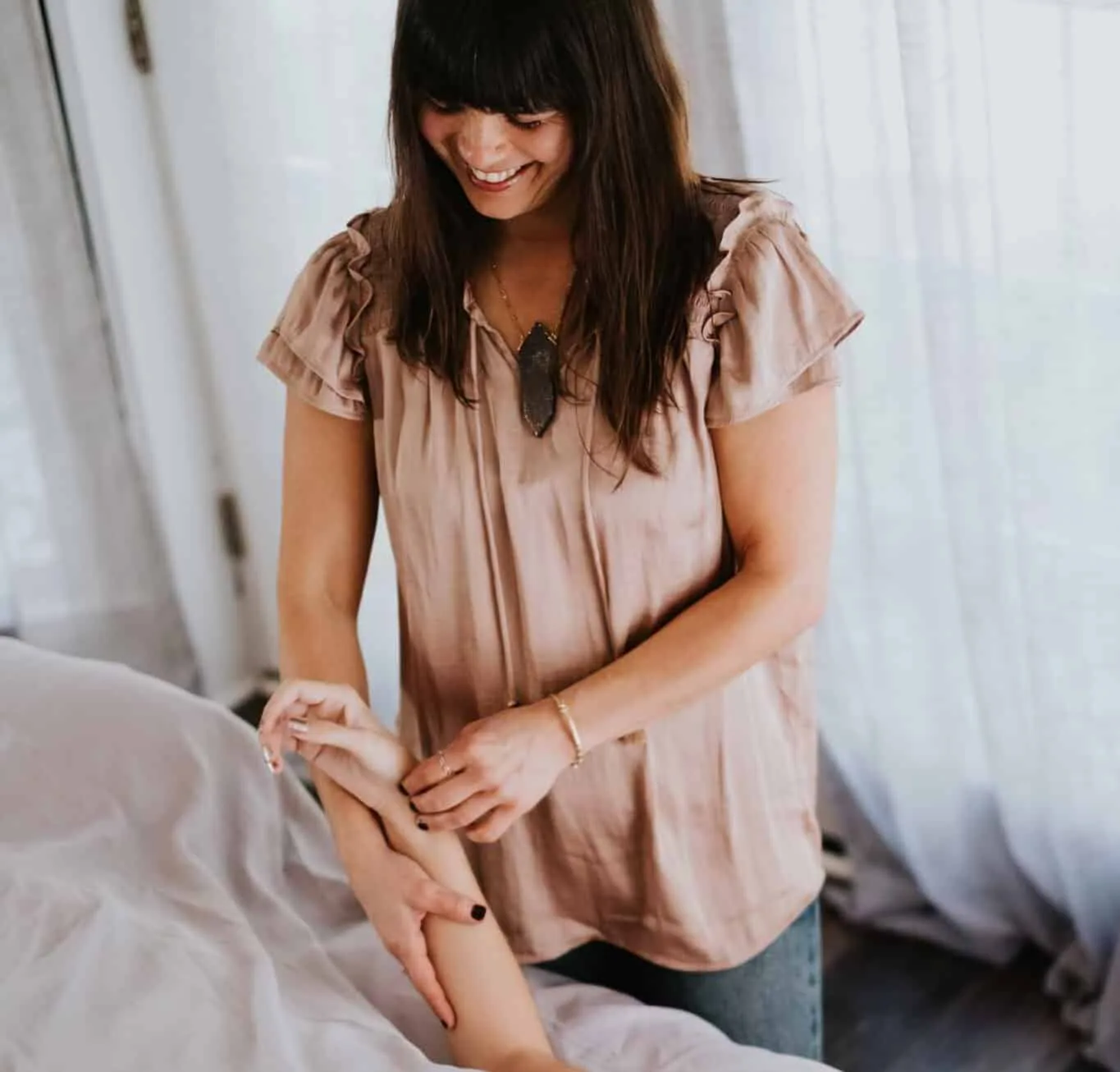 Briana J. Sabaj assessing a client’s arm during a hands-on session