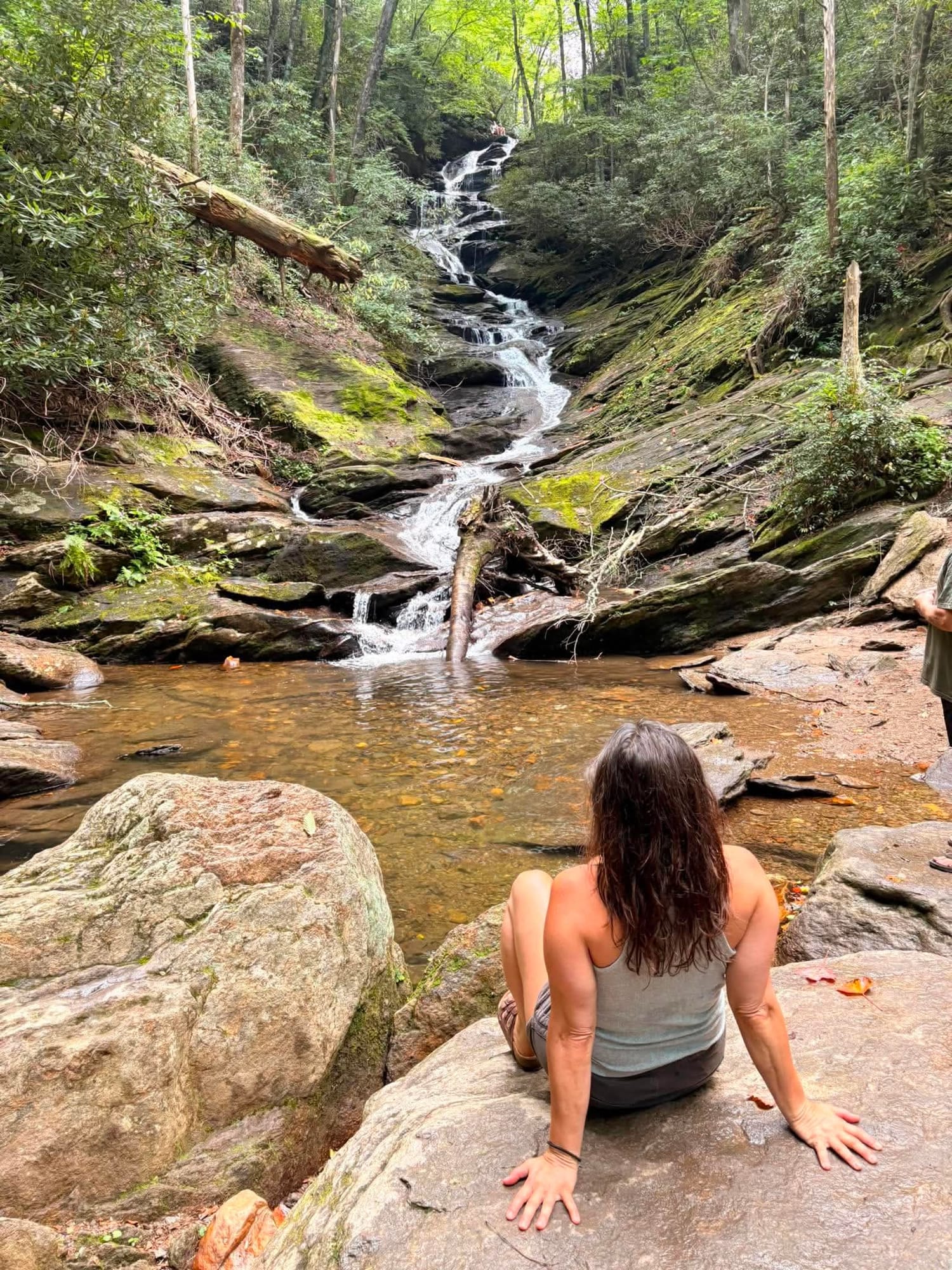 Briana sitting on a rock at a Blue Ridge waterfall